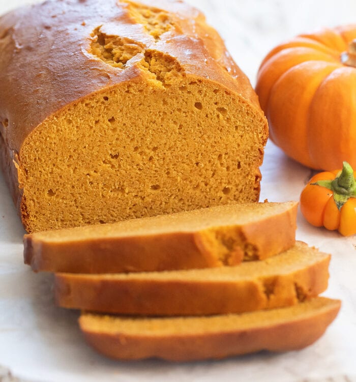 a loaf of pumpkin bread with three slices cut off.