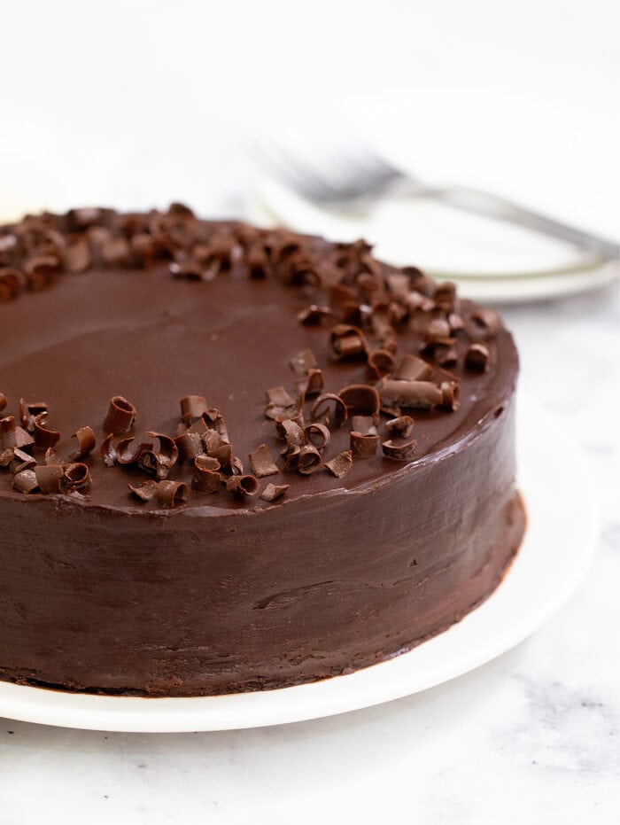a whole frosted cake garnished with chocolate curls.