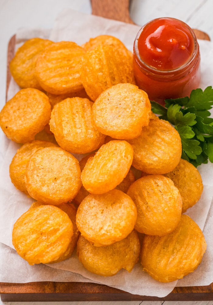 a plate of crispy potato pillows with ketchup on the side.