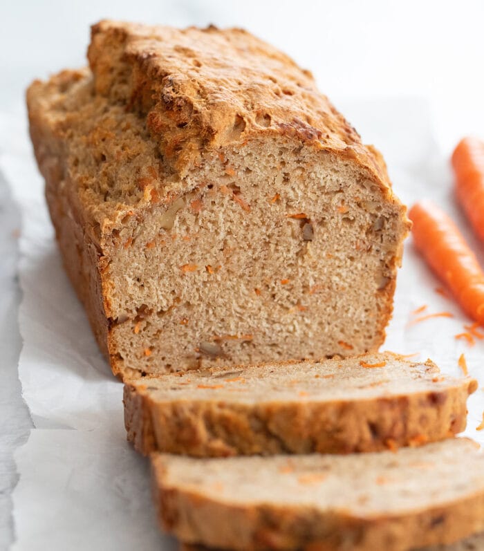 a loaf of carrot cake bread with slices cut off.