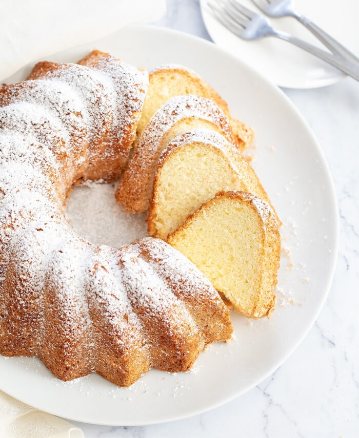 Bundt cake topped with powdered sugar and slices cut out of it