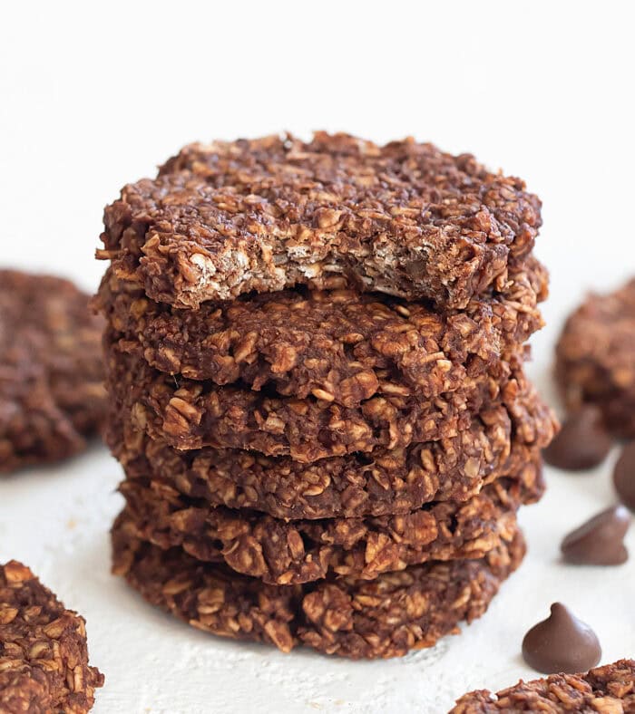 Chocolate oatmeal cookies stacked with the top cookie with a bite out if it