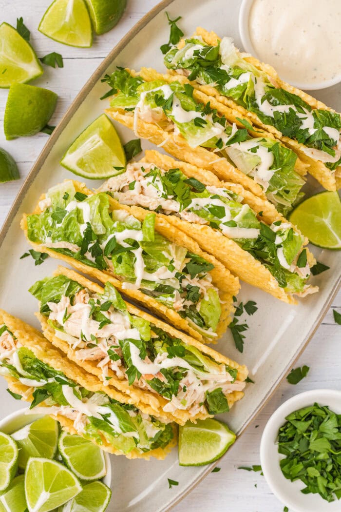 Chicken Caesar salad tacos lined up on an oval serving dish