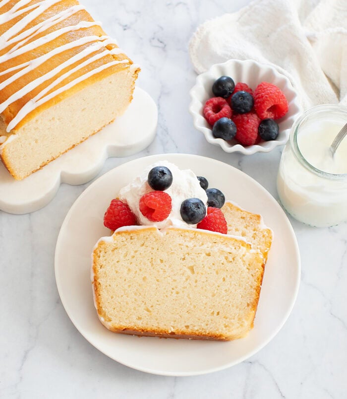 Slices of French yogurt cake topped with whipped cream and berries