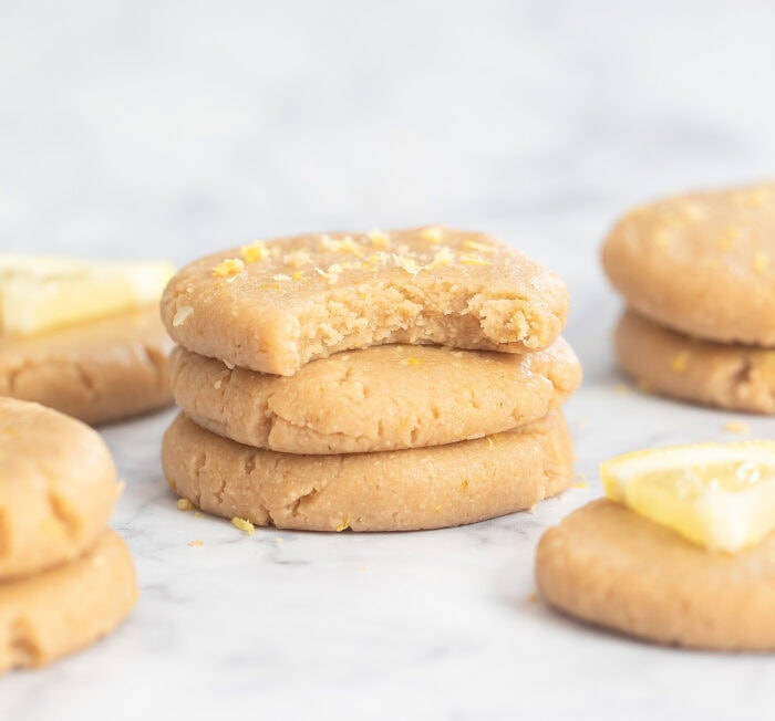 Three lemon cookies with a bite taken from one