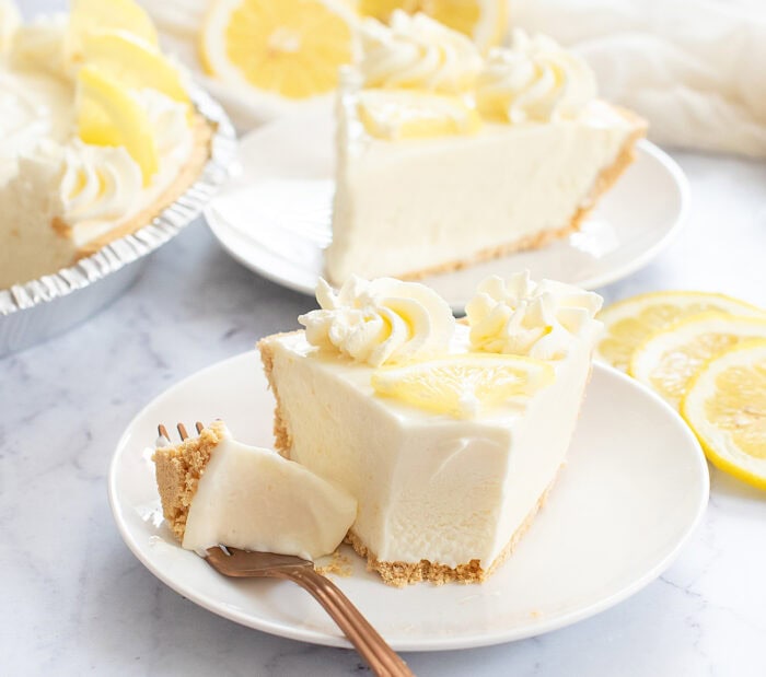 Slice of lemonade pie with a bite on a fork