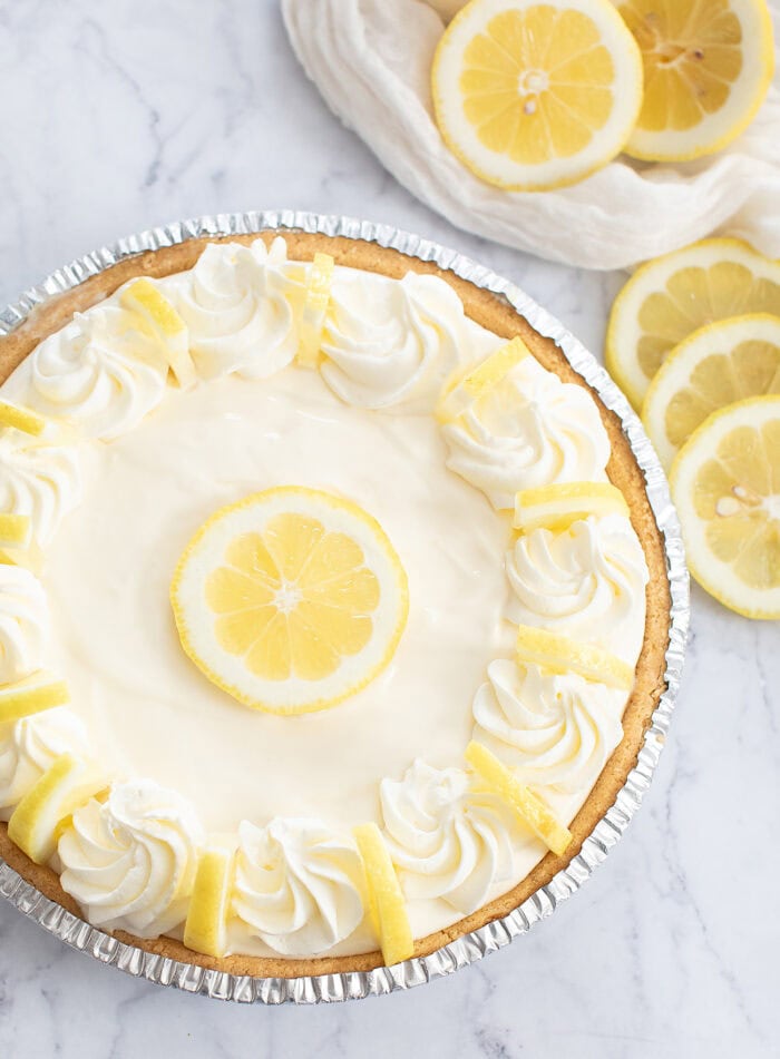 Lemonade pie topped with whipped cream and lemon slices