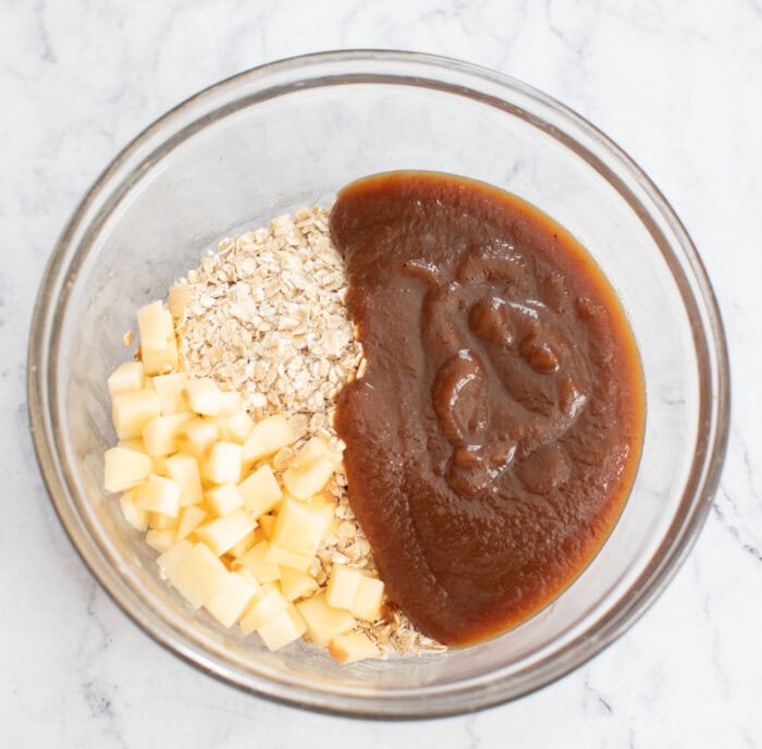 Quick oats, apple cubes and apple butter in a glass bowl