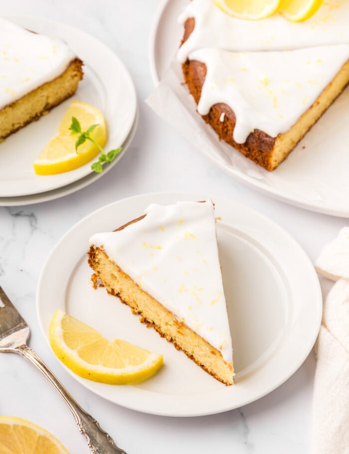 A slice of lemon cake with a lemon wedge