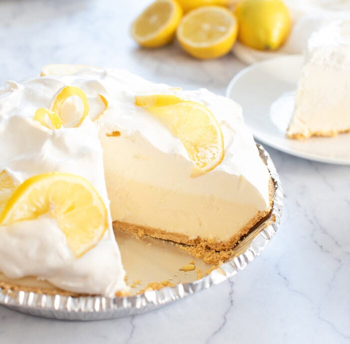 Lemon cloud pie with a slice cut from it