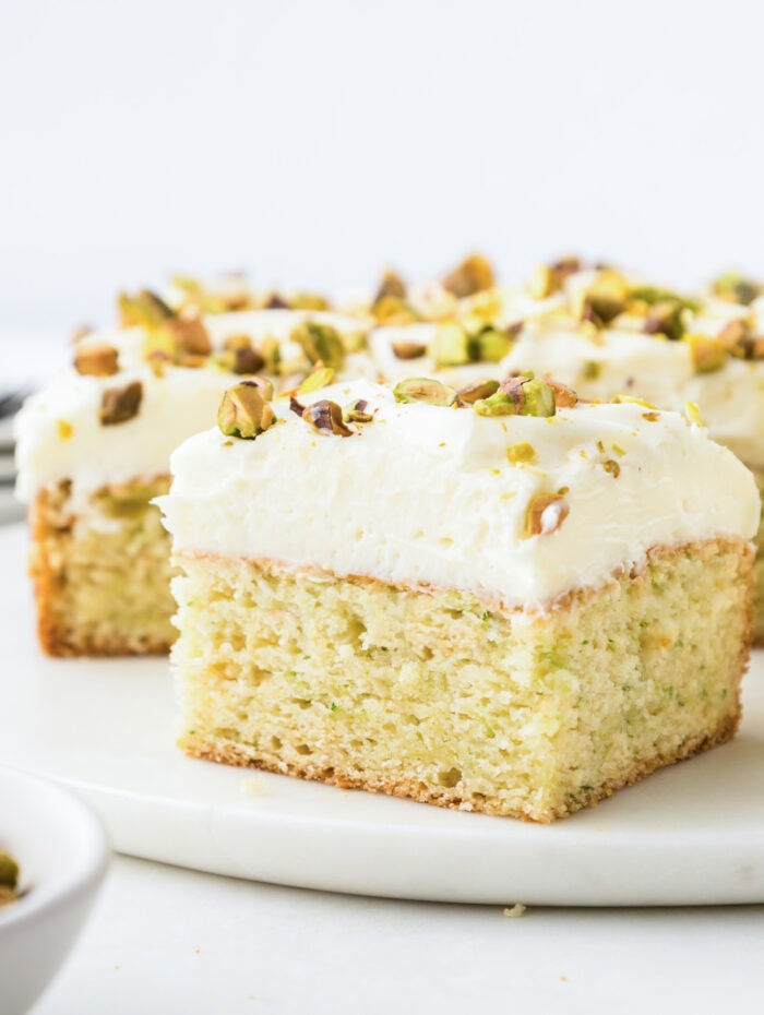 Zucchini cake with cream cheese frosting and topped with chopped nuts