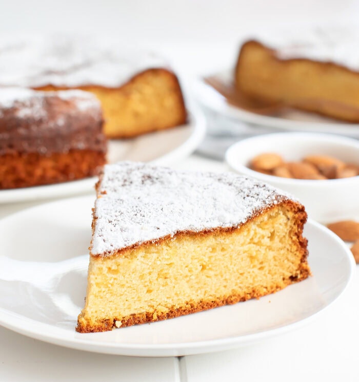 A slice of almond cake on a white plate