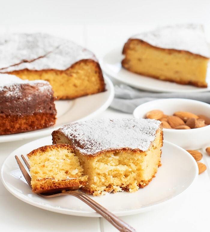 A slice of almond cake with a piece on a fork