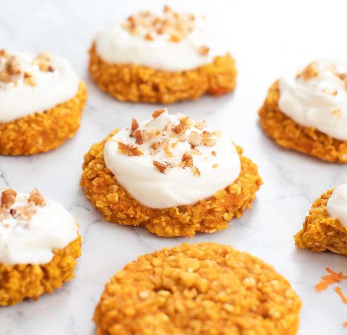 Carrot Cake Oatmeal Cookies with frosting and chopped pecans on top