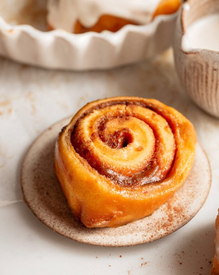 A carrot cake cinnamon roll on a plate
