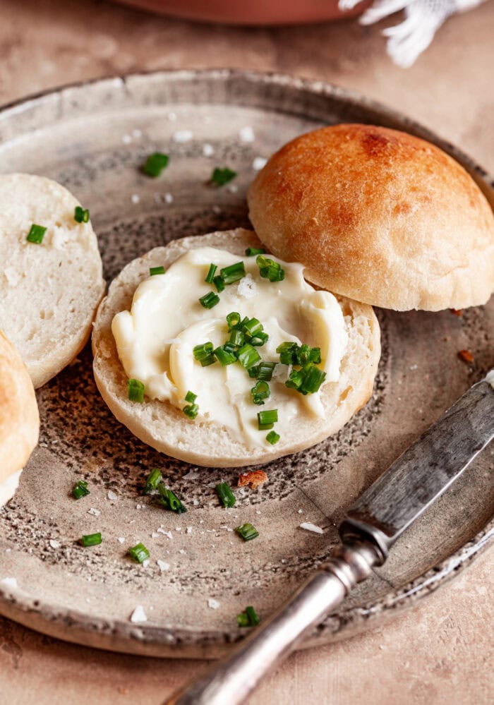 A bread roll with butter and herbs