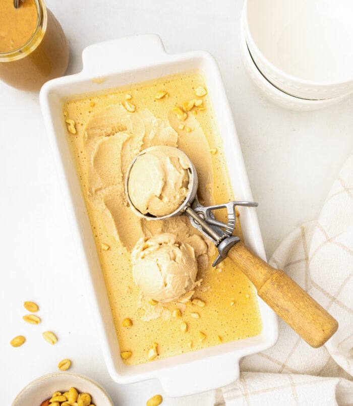 Scooping out peanut butter ice cream from a loaf pan