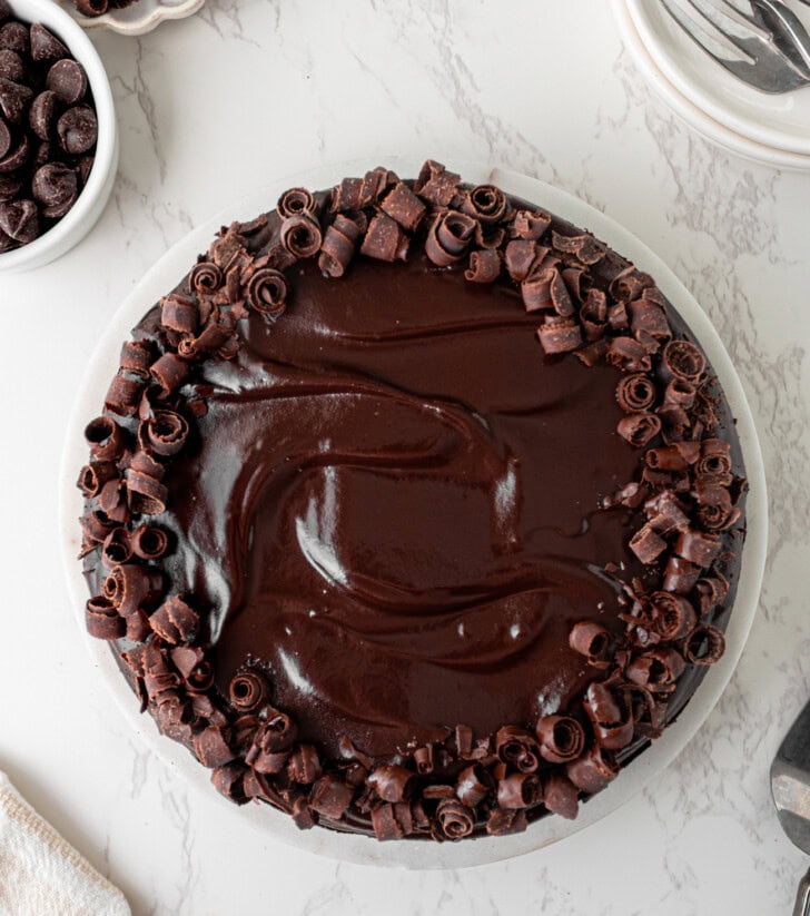 A chocolate cake decorated with chocolate frosting and chocolate shavings