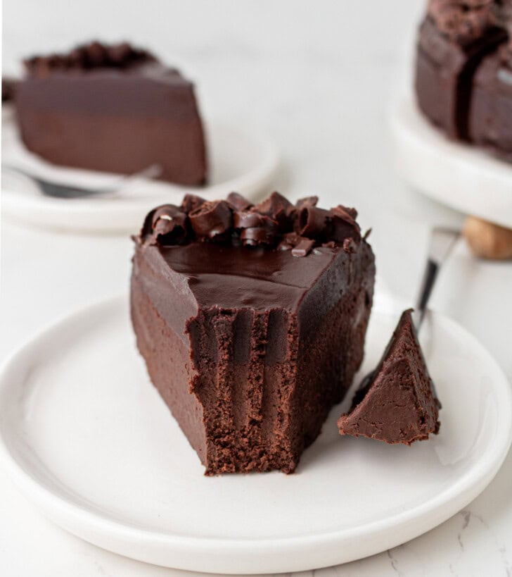 A bite taken from a slice of chocolate cake