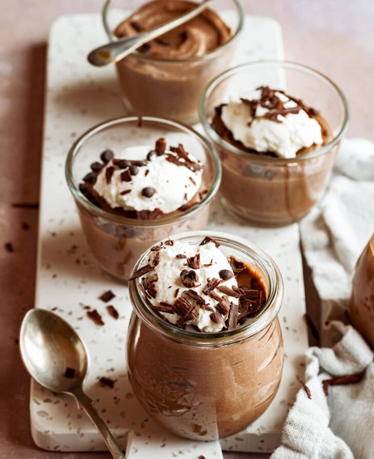 Chocolate mousse in glass jars on a serving board