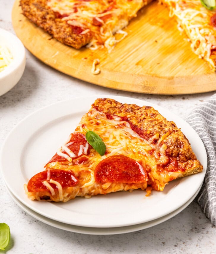 A slice of pepperoni pizza on a small white plate