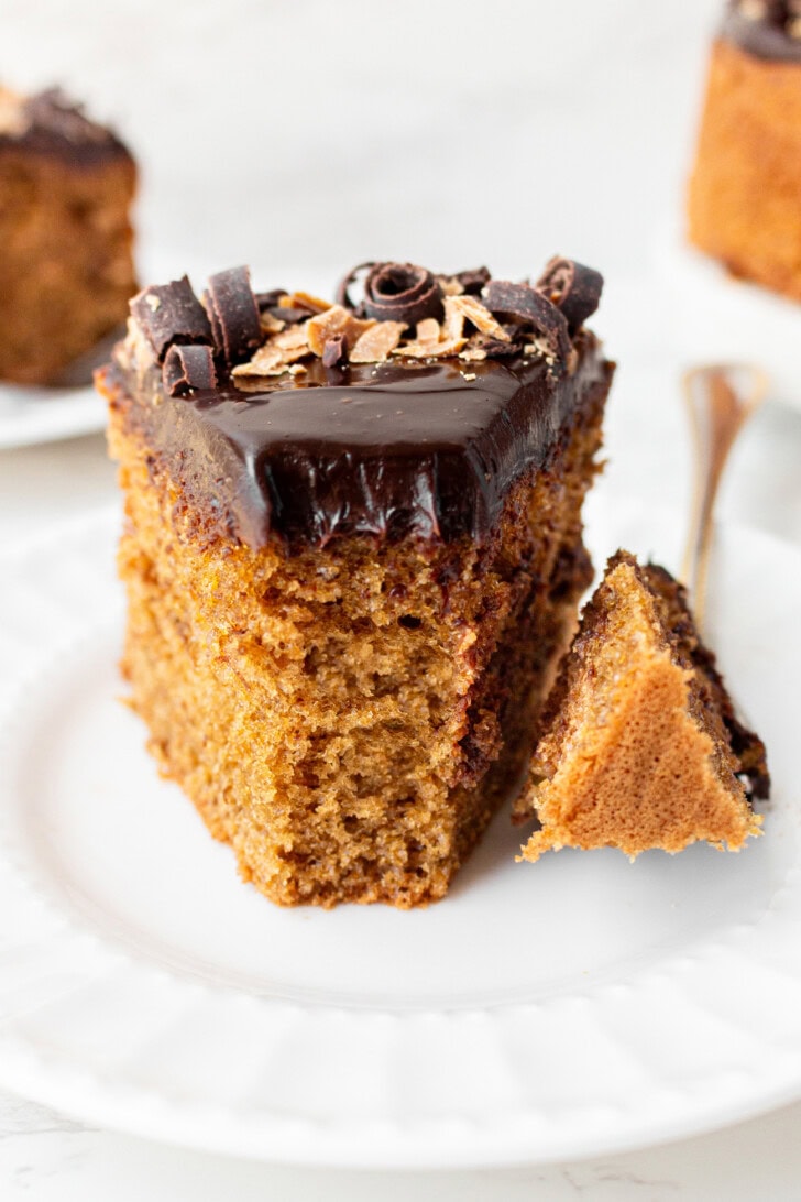 A bite taken from a slice of peanut butter cake