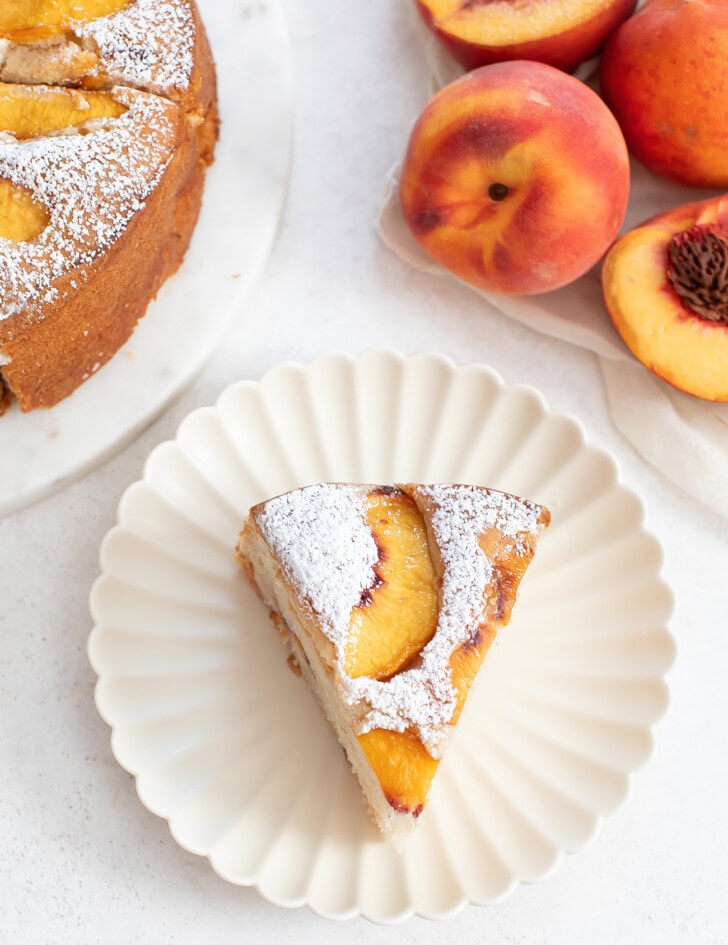 A slice of cake with fresh peaches