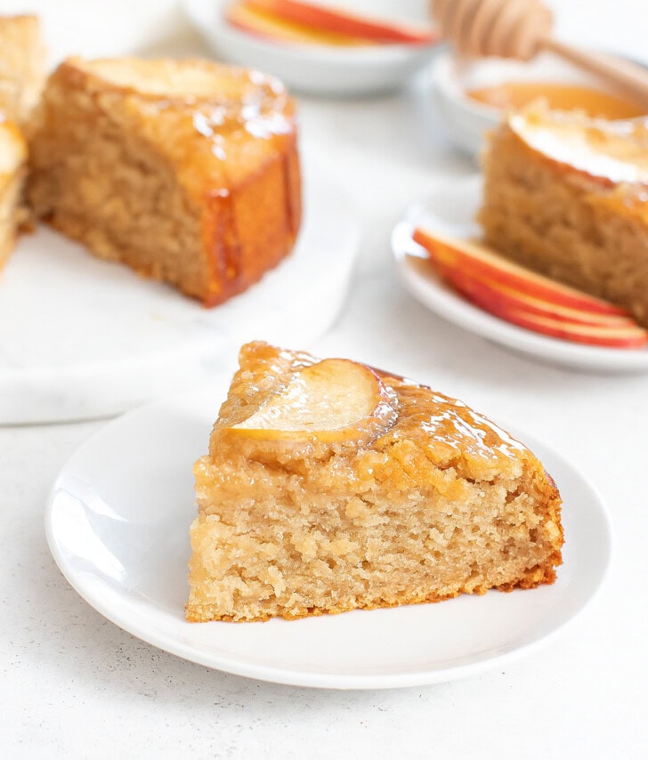 A slice of apple cake on a white plate