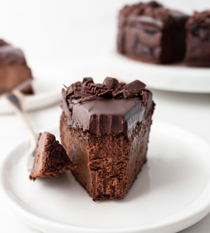 A bite taken from a slice of chocolate cake