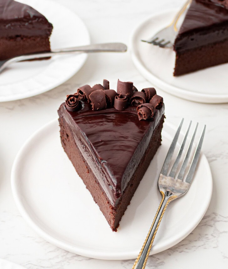 A slice of chocolate cake on a plate with a fork