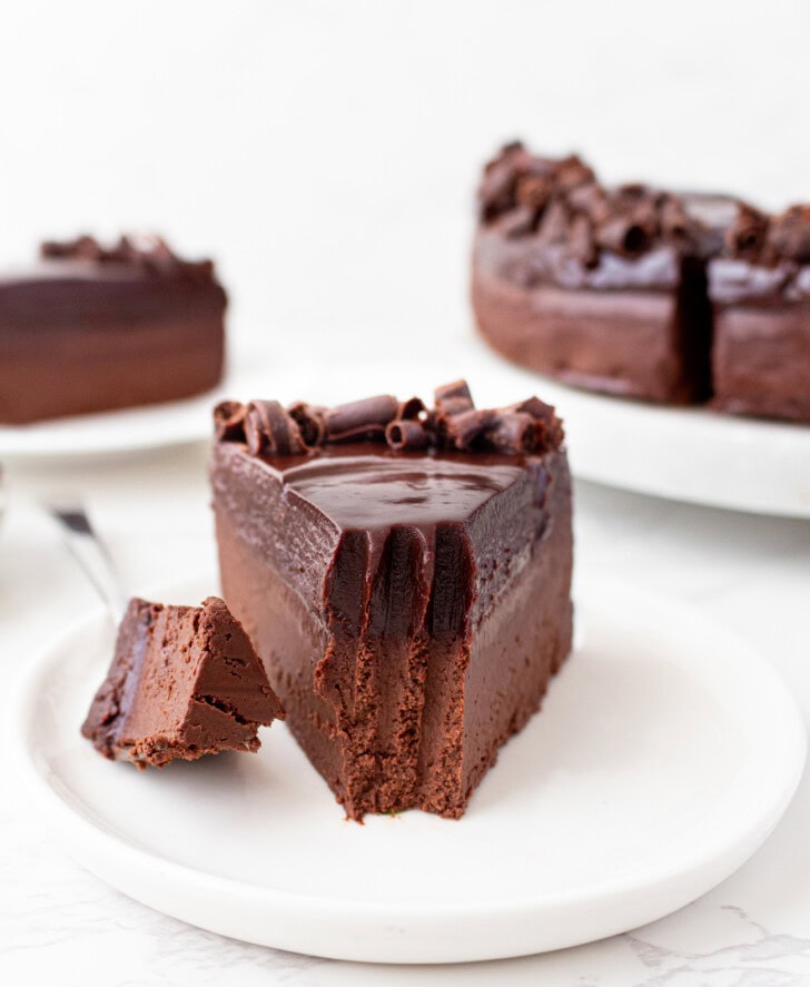 A bite taken from a slice of chocolate cake