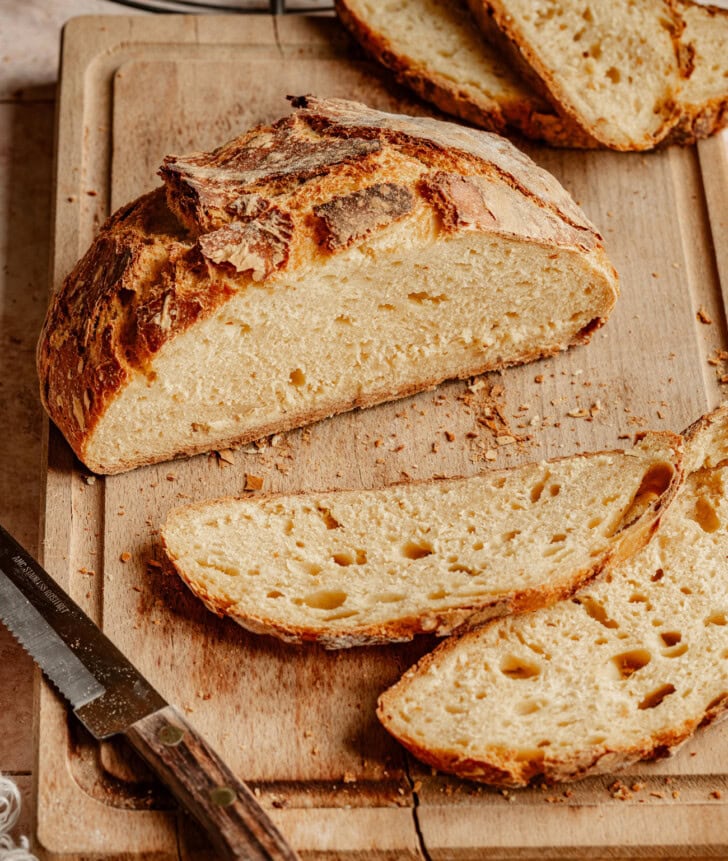 Pumpkin bread on a wood cutting board cut into slices
