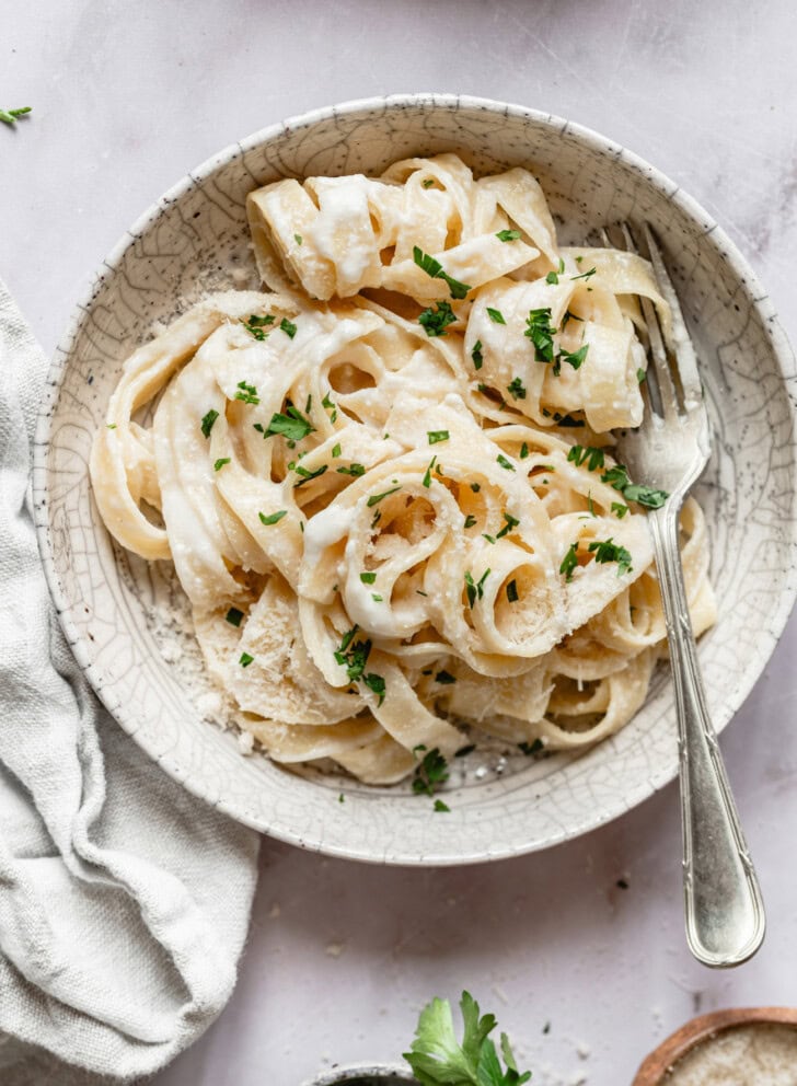 Fettuccine Alfredo in a bowl with freshly grated parmesan