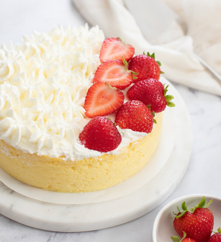 A cottage cheese cake with whipped cream frosting and fresh strawberries