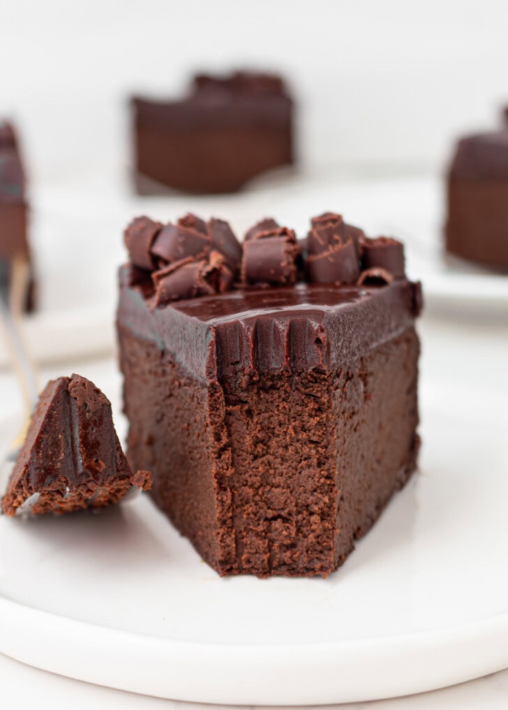 A bite taken from a slice of chocolate cake