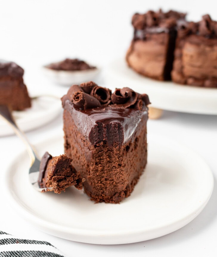 A bite taken from a slice of chocolate cake