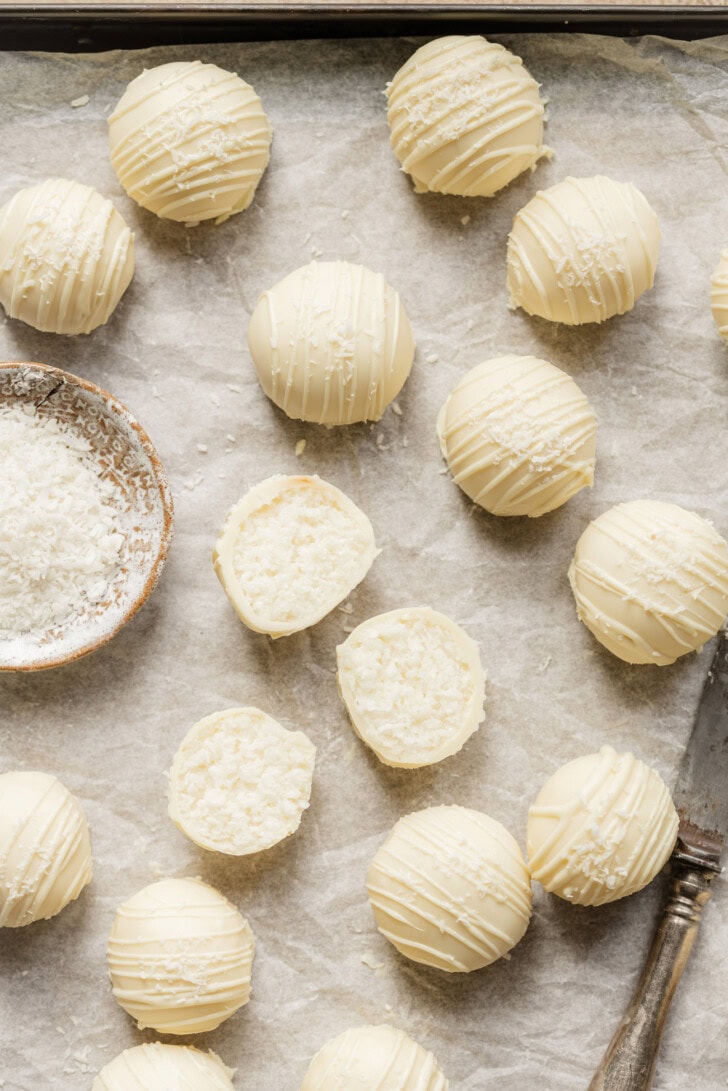 Coconut truffles with a white chocolate drizzle and shredded coconut on top