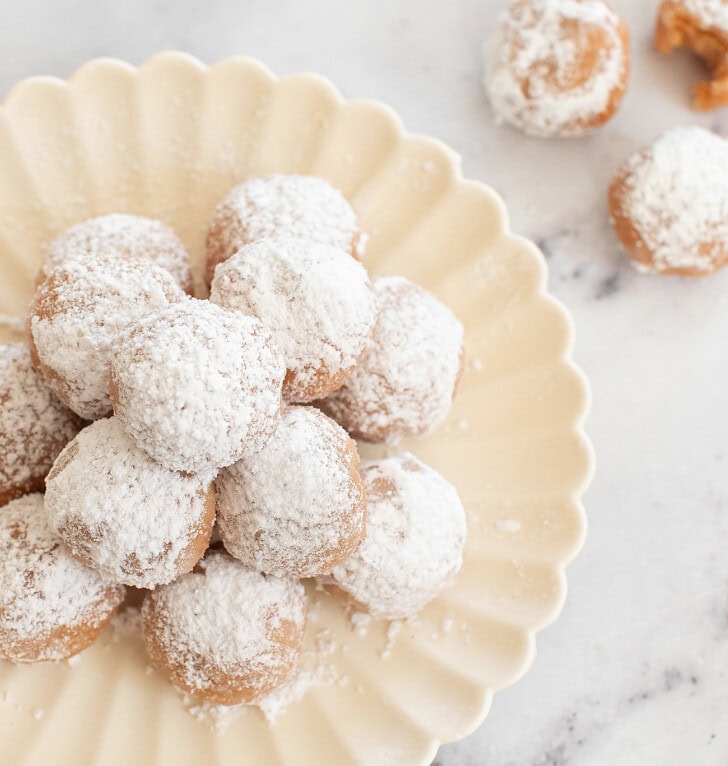 A plate of Snowball Cookies with powdered sugar on top
