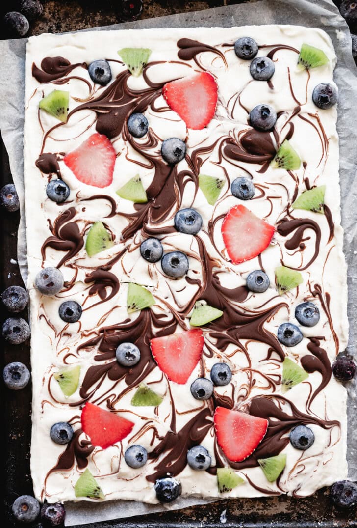 Yogurt bark on a pan with fruit and chocolate on top