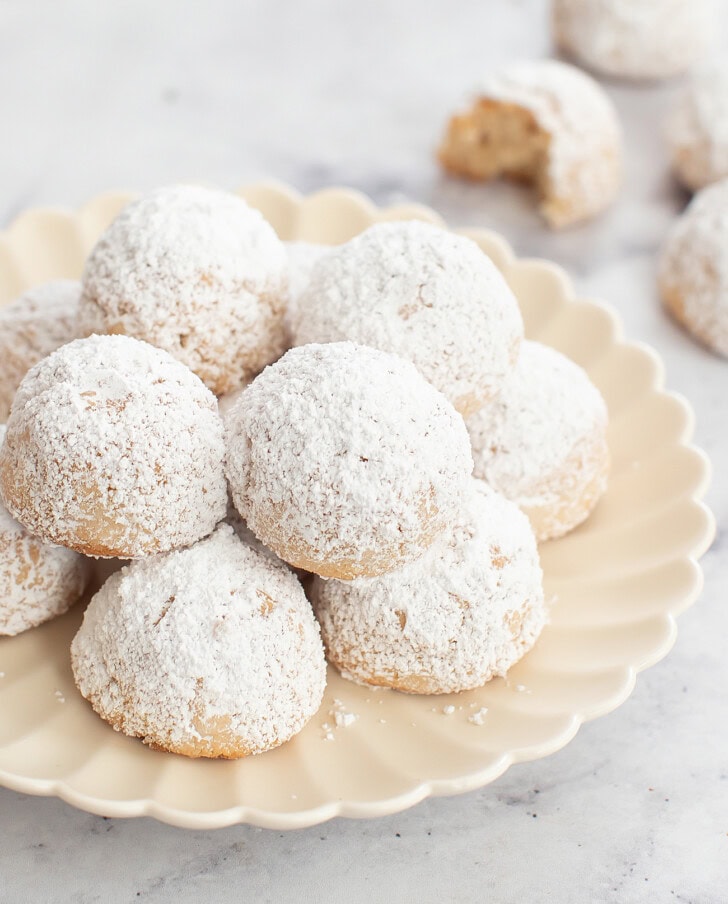 A plate of snowball cookies dusted with powdered sweetener