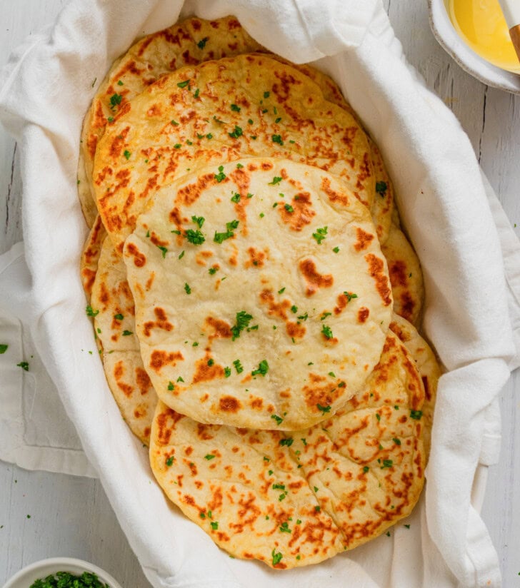 Flatbread with fresh herbs on top in a bread basket