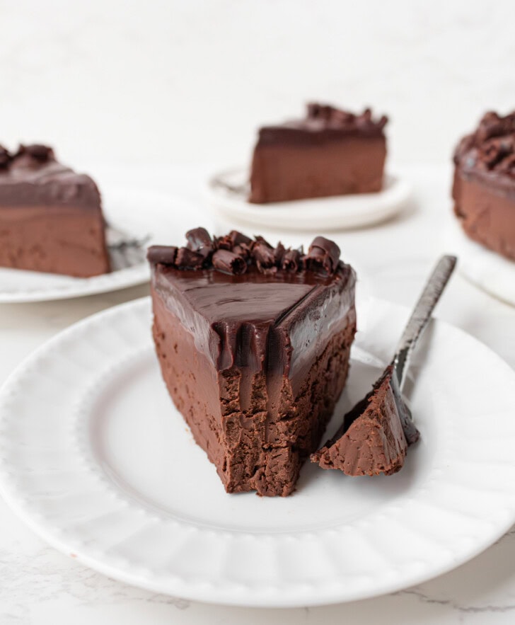 A bite taken from a slice of chocolate cake