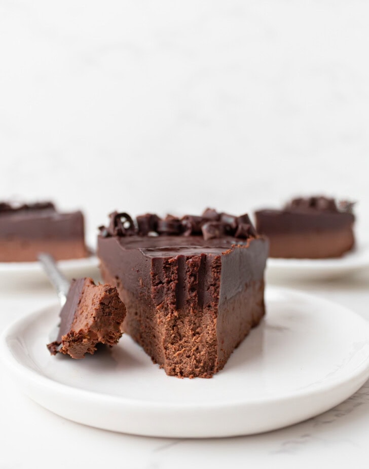 A bite on a fork taken from a slice of chocolate cake