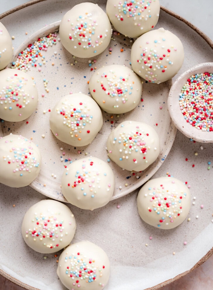 Cake balls dipped in white chocolate with sprinkles on top