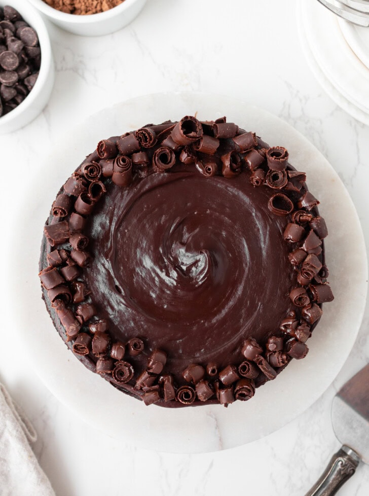 A chocolate cake decorated with frosting and chocolate curls