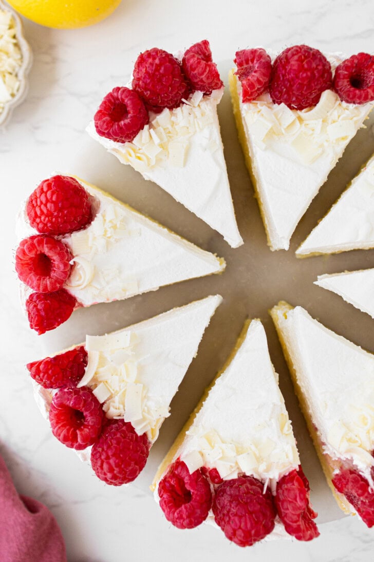Cottage Cheese Cake decorated with whipped cream and fresh raspberries