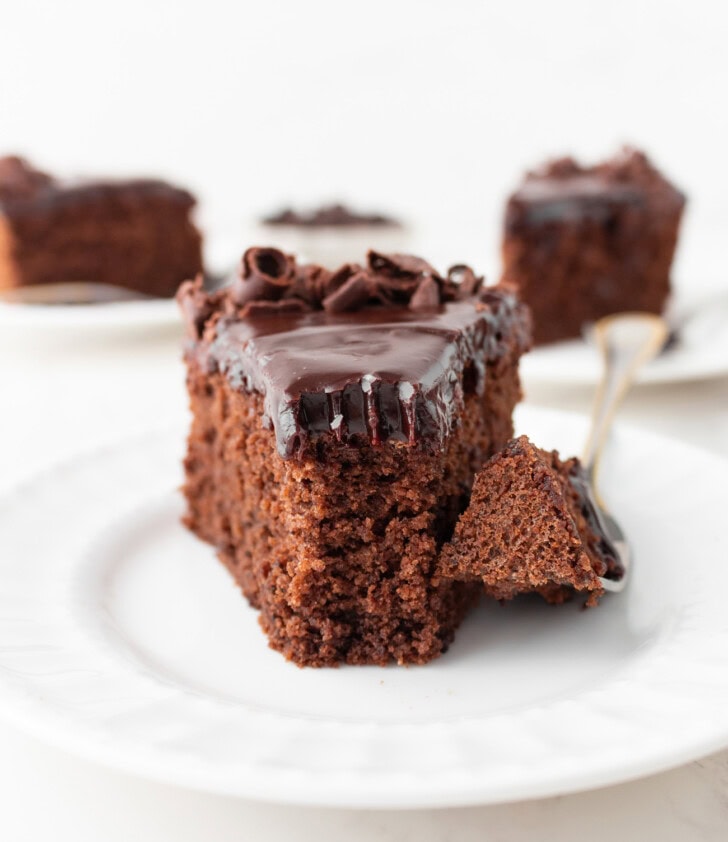 A bite of cake on a fork taken from a slice of chocolate cake
