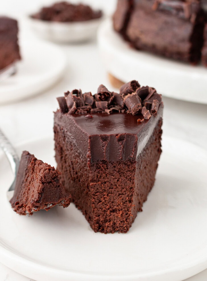 A bite taken from a slice of chocolate cake