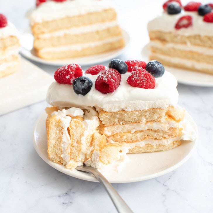 A bite of cake on a fork next to a slice on a plate