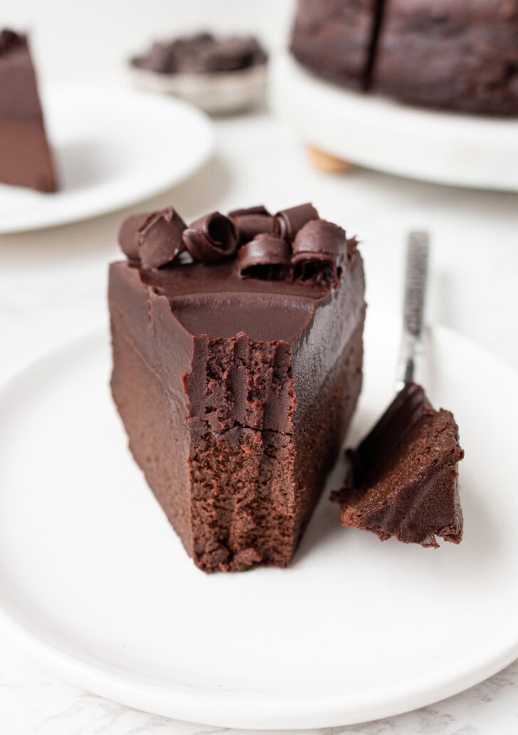 A bite on a fork taken from a slice of chocolate cake